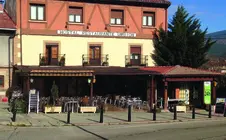 Fachada del Hostal Restaurante Urbi&oacute;n junto a la amplia terraza en la localidad de Vinuesa