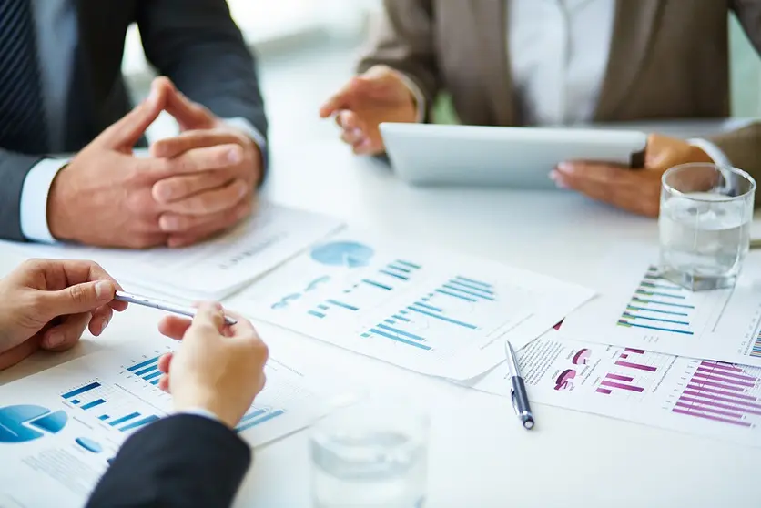 Image of business documents, pen and glasses on workplace during meeting of partners