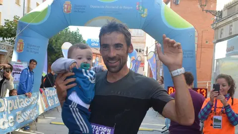 LUIS ALBERTO HERNANDO, CAMPEÓN DEL MUNDO DE CARRERAS DE MONTAÑA 2017 A LA LLEGADA A META SOSTENIENDO A SU HIJO