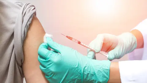 Vaccination healthcare concept. Hands of doctor or nurse in medical gloves injecting a shot of vaccine to a man patient (Vaccination healthcare concept. Hands of doctor or nurse in medical gloves injecting a shot of vaccine to a man patient, ASCII, 12