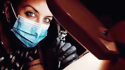 Davinia tatuando en su estudio