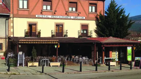 Fachada del Hostal Restaurante Urbi&oacute;n junto a la amplia terraza en la localidad de Vinuesa