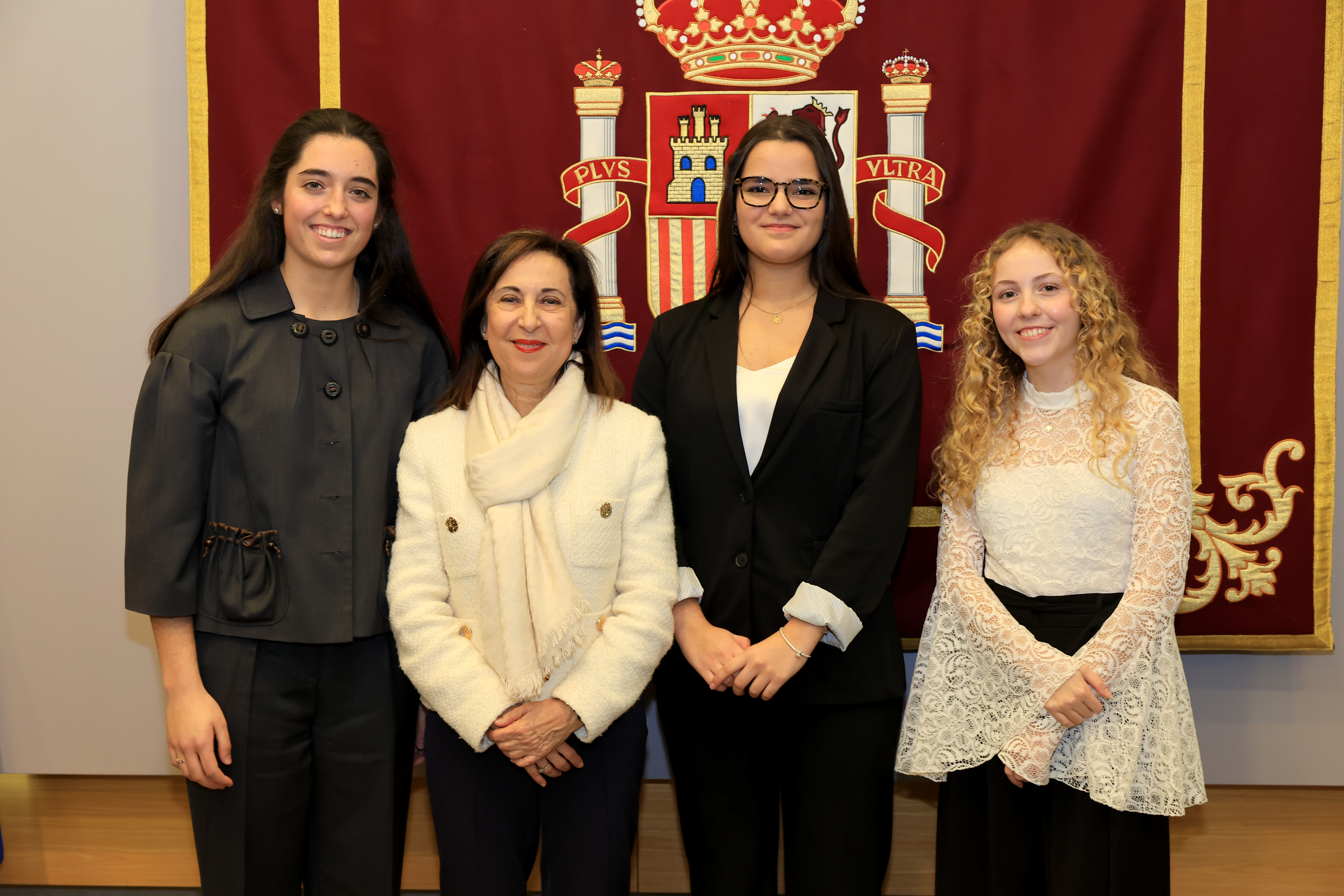 La ganadora con las dos finalistas y la ministra de defensa